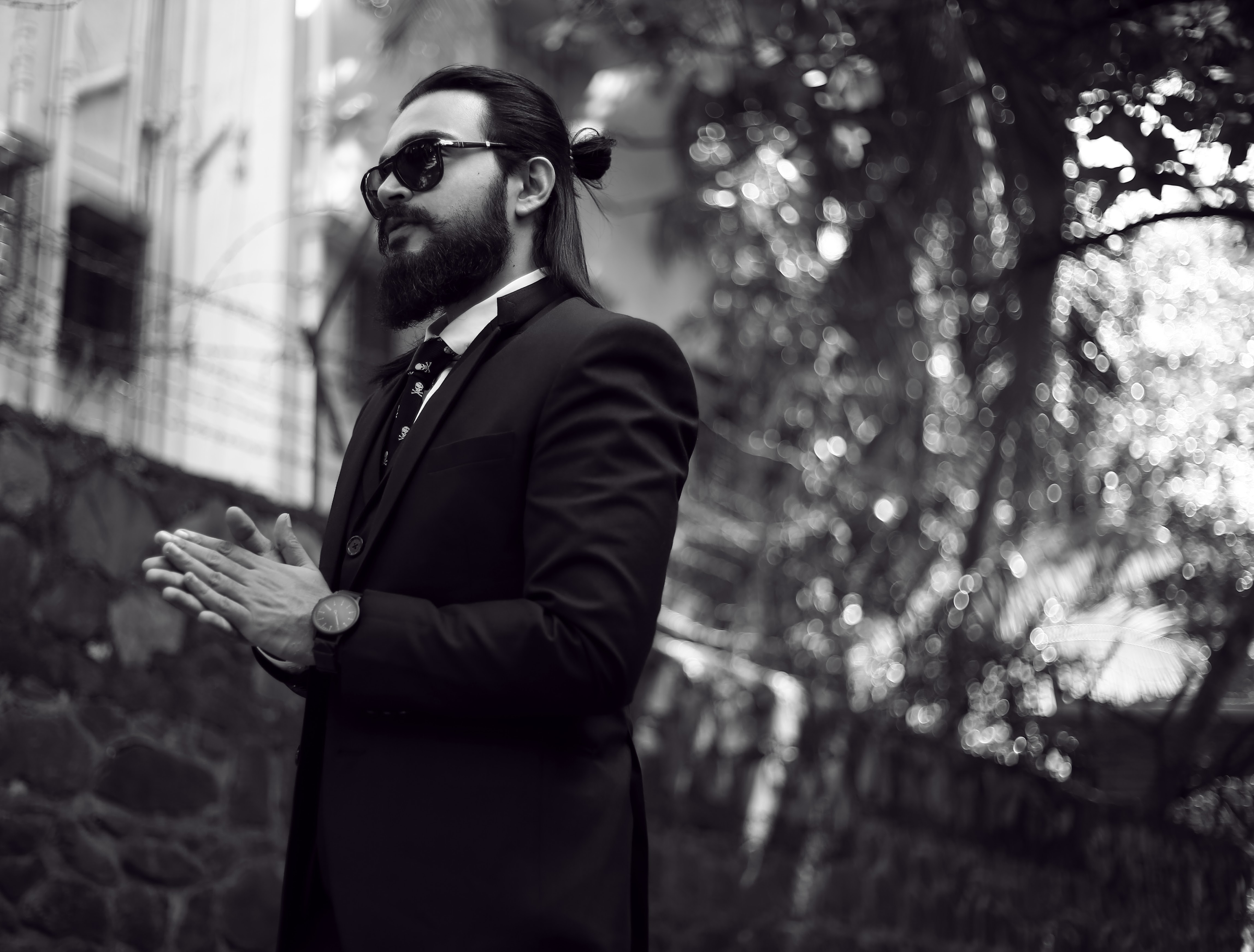 Mumbai-based singer, songwriter, and guitarist Umang Mehta wearing a suit, and skull-print tie in a vintage, artistic outdoor setting.
